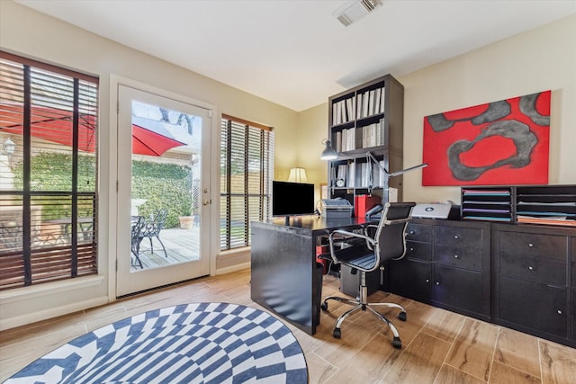 home office with visible vents and wood finished floors