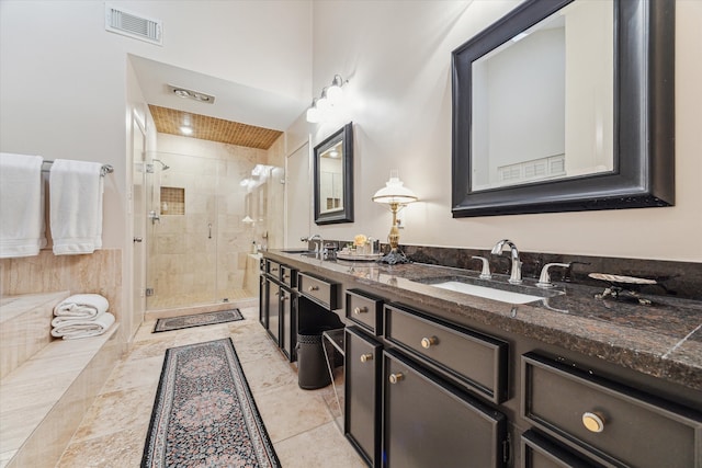 full bath featuring double vanity, a shower stall, visible vents, and a sink