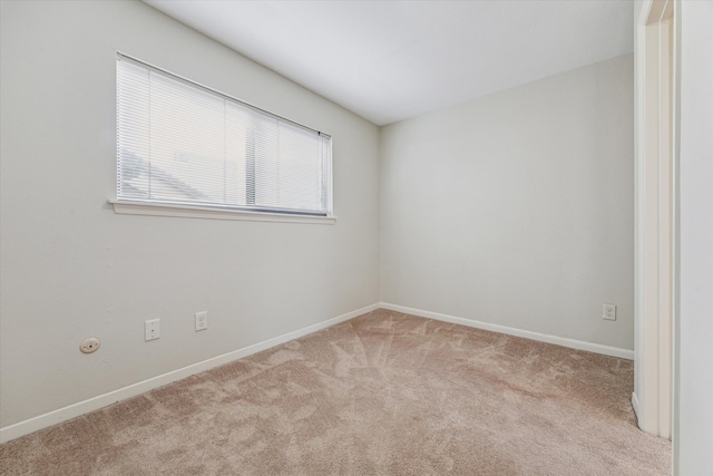 carpeted spare room with baseboards