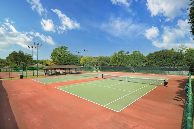 view of tennis court featuring community basketball court and fence