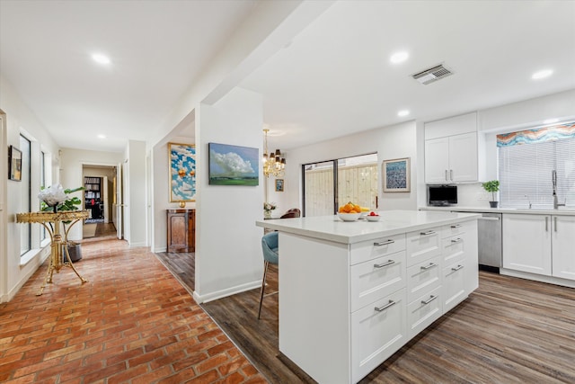 kitchen with a sink, visible vents, white cabinetry, light countertops, and dishwasher