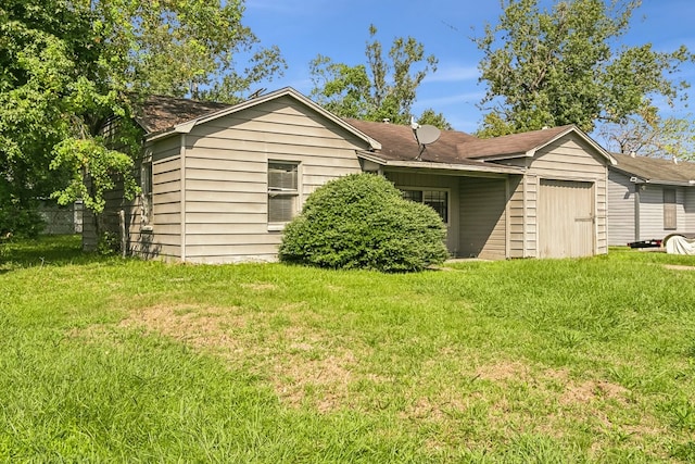 exterior space featuring an attached garage and a yard