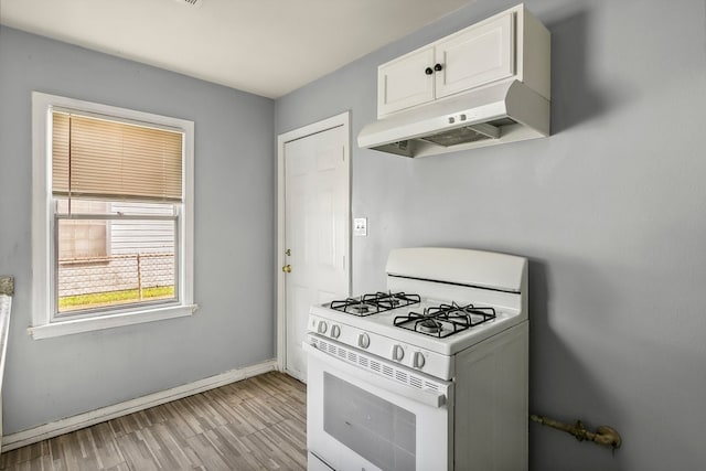 kitchen with white cabinetry, white range with gas cooktop, light wood-type flooring, under cabinet range hood, and baseboards