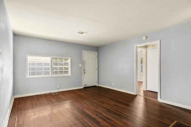 spare room featuring baseboards, visible vents, and hardwood / wood-style floors