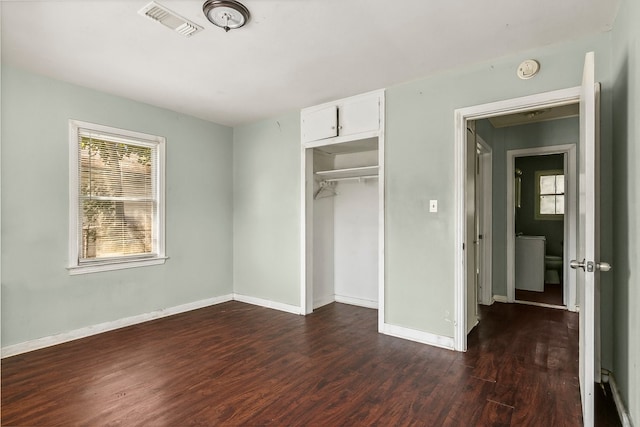 unfurnished bedroom featuring multiple windows, wood finished floors, and baseboards