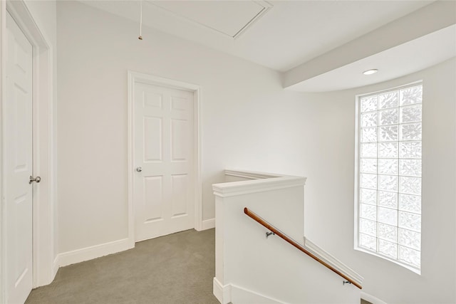 corridor with baseboards, carpet flooring, an upstairs landing, and attic access