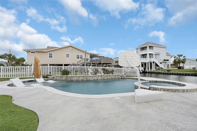 view of pool featuring a residential view, a pool with connected hot tub, a fenced backyard, and stairway