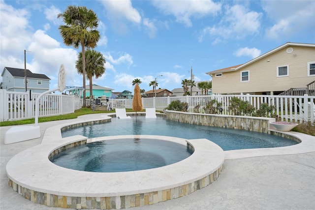 view of pool featuring a residential view, a pool with connected hot tub, and a fenced backyard