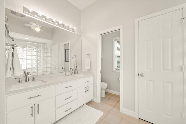 bathroom featuring tile patterned flooring, a sink, toilet, and ceiling fan