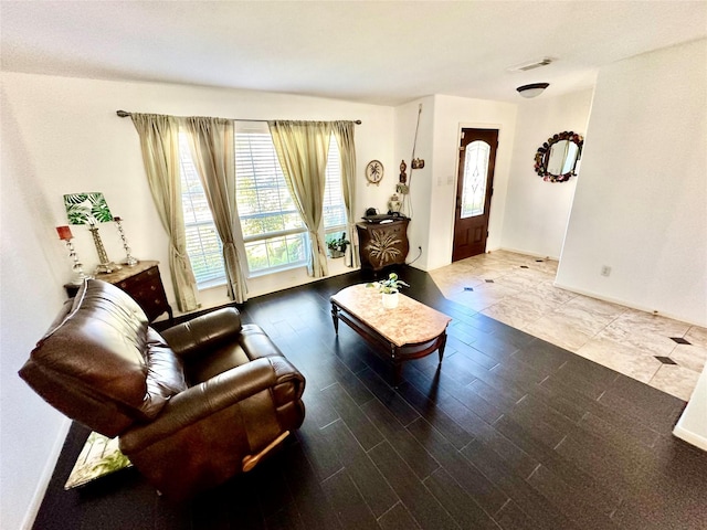 living area featuring wood finished floors, visible vents, and baseboards