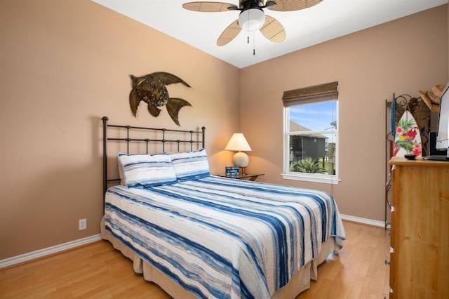 bedroom with ceiling fan, baseboards, and wood finished floors