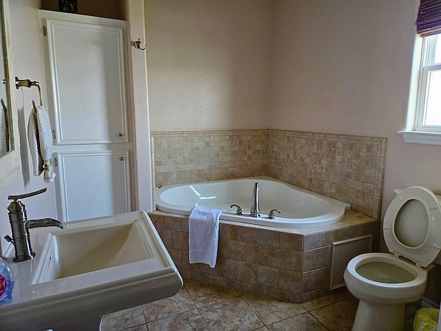 full bath with toilet, a garden tub, and a sink