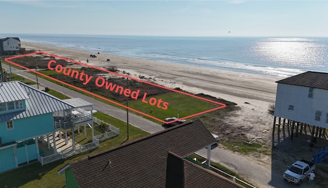 drone / aerial view featuring a water view and a view of the beach