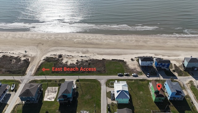 birds eye view of property featuring a water view and a beach view