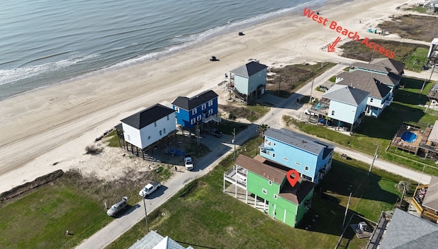 birds eye view of property featuring a water view and a beach view