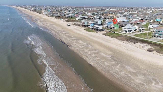 bird's eye view featuring a view of the beach, a water view, and a residential view