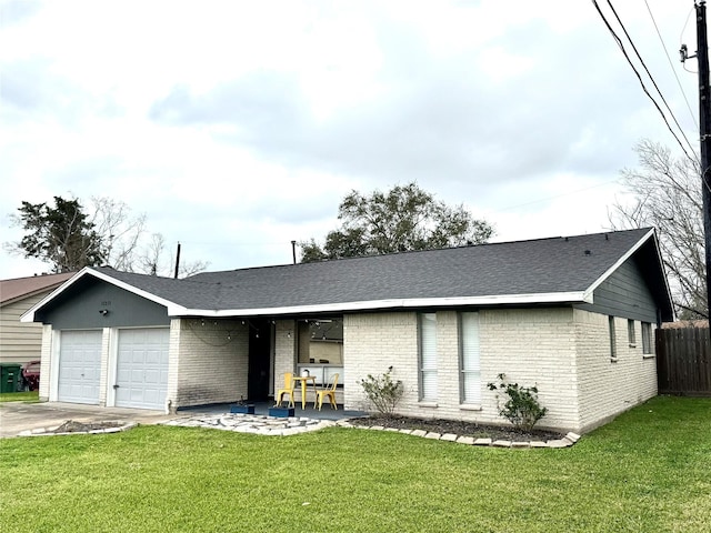 view of front of home with a garage, concrete driveway, fence, a front yard, and brick siding