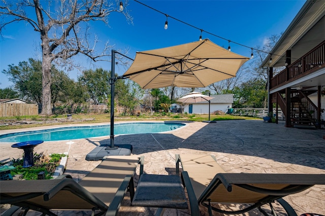 pool featuring stairs, a patio, and fence