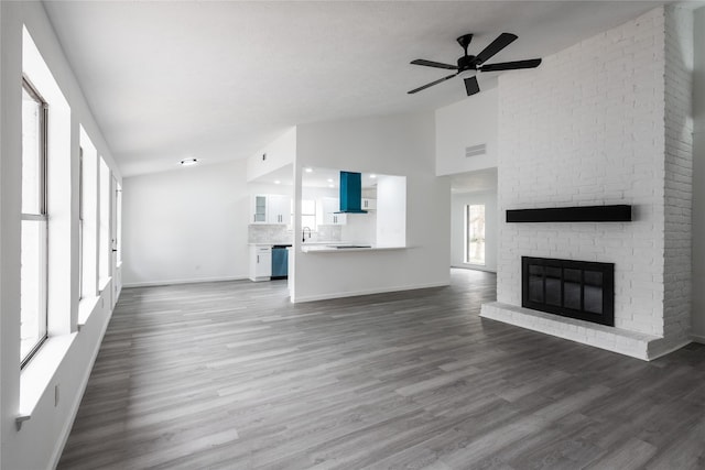 unfurnished living room featuring a fireplace, visible vents, ceiling fan, wood finished floors, and baseboards