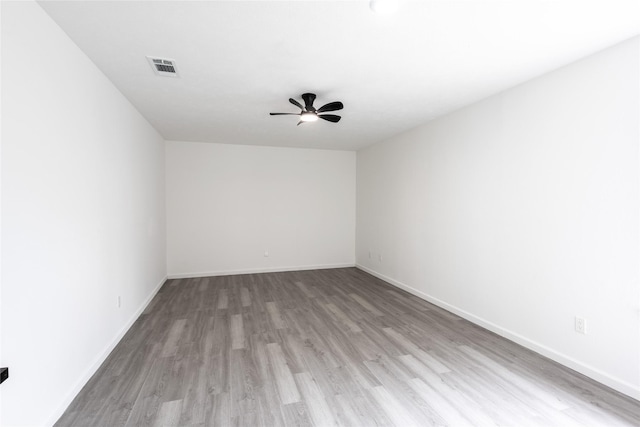 unfurnished room featuring baseboards, light wood finished floors, visible vents, and a ceiling fan