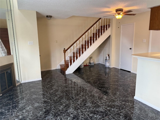 2120 El Paseo St Unit 3301, Houston, TX 77054 - unfurnished living room with stairs, a textured ceiling, marble look tiles, and a ceiling fan