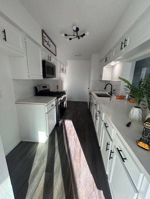 kitchen featuring stainless steel appliances, light countertops, dark wood-type flooring, and a sink