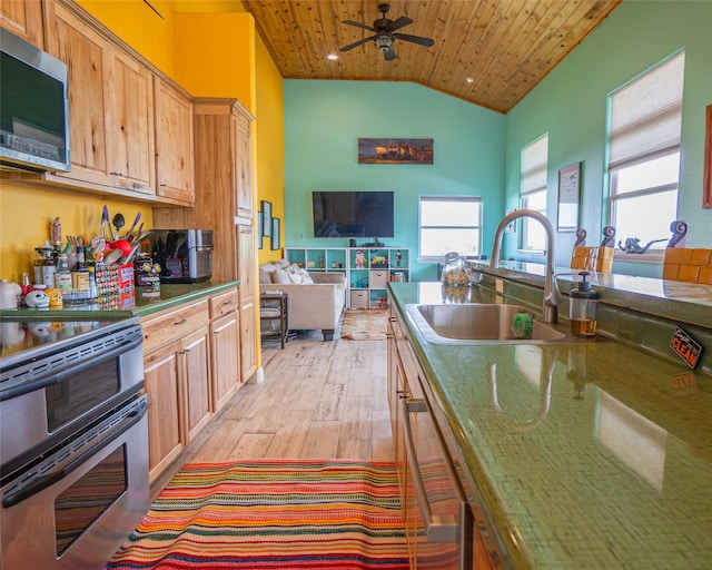 kitchen with a sink, wood ceiling, light wood-style floors, vaulted ceiling, and appliances with stainless steel finishes