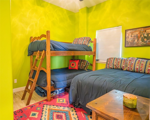 bedroom with baseboards and wood finished floors