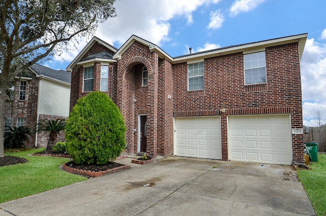 traditional-style house with an attached garage, a front yard, concrete driveway, and brick siding