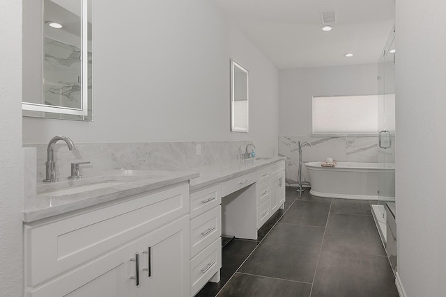 bathroom featuring a sink, a soaking tub, tile walls, and double vanity