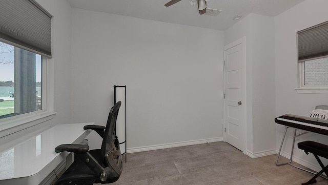 office area with baseboards, visible vents, and ceiling fan