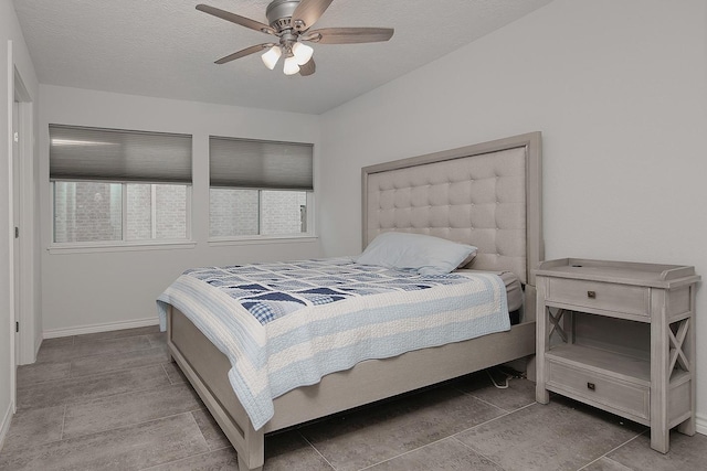 bedroom with a textured ceiling, baseboards, and a ceiling fan