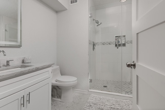 full bathroom featuring vanity, visible vents, baseboards, a stall shower, and toilet