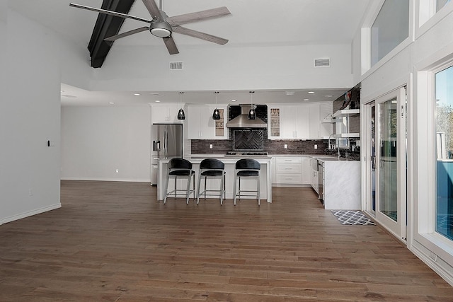 kitchen with decorative backsplash, wall chimney exhaust hood, visible vents, and stainless steel appliances