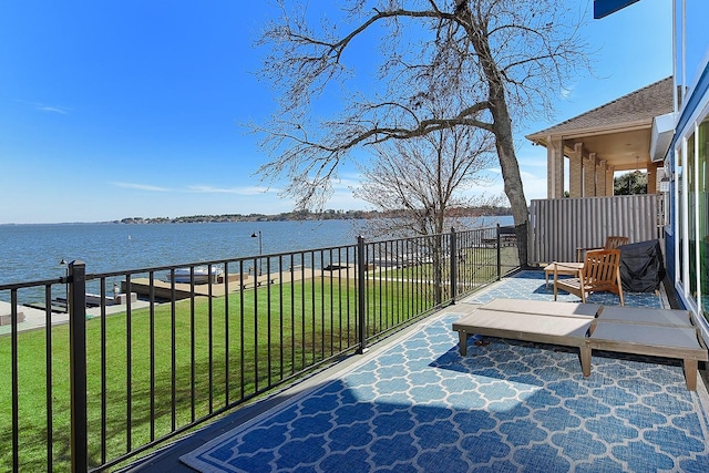 wooden terrace with a yard and a water view