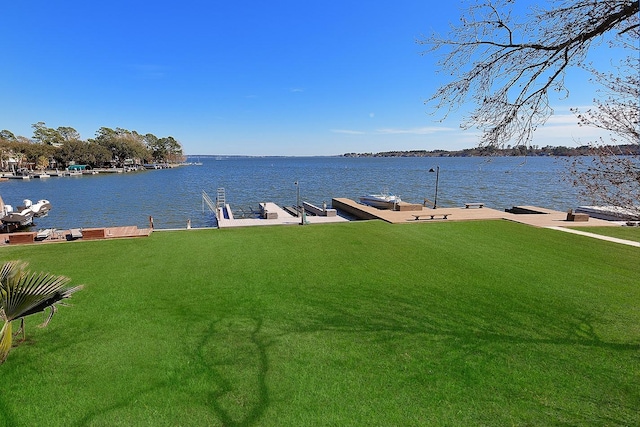 dock area featuring a lawn and a water view