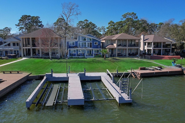 view of dock with a lawn and a water view