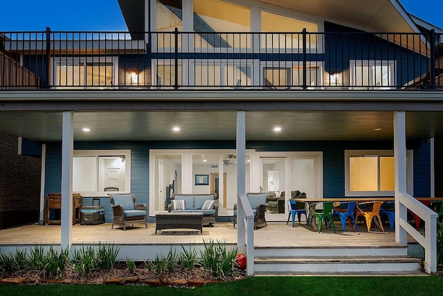 back of property with an outdoor living space and a balcony