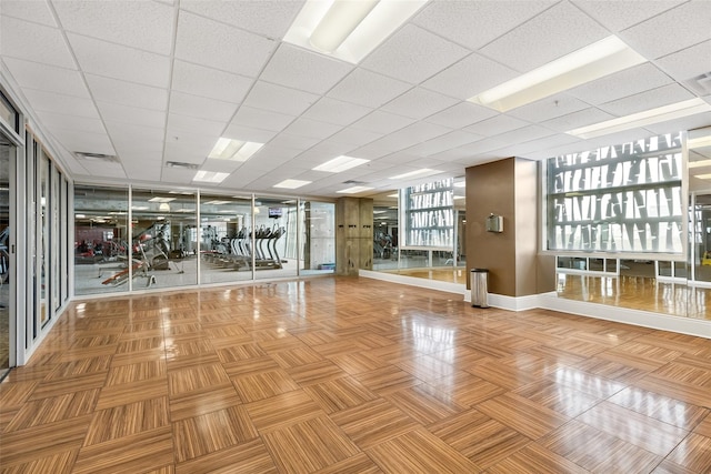 workout area featuring a paneled ceiling, baseboards, and visible vents