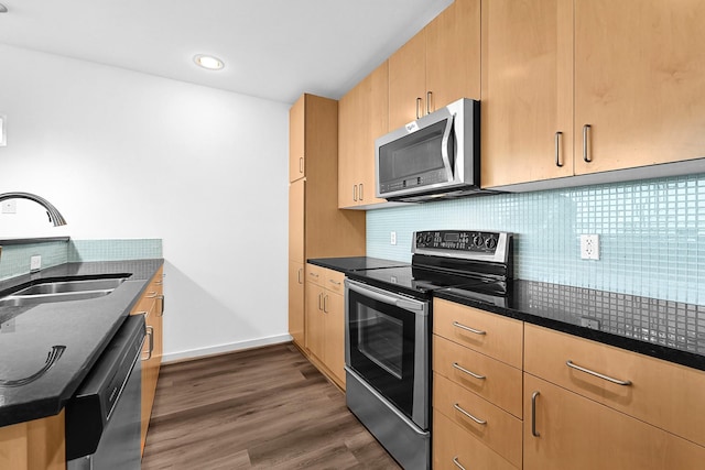 kitchen featuring decorative backsplash, dark wood-style flooring, stainless steel appliances, light brown cabinets, and a sink