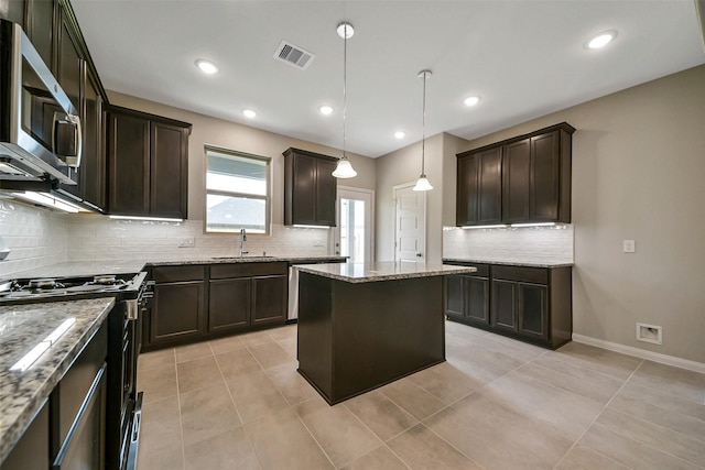 4215 Sternside Ln, Houston, TX 77053 - kitchen featuring appliances with stainless steel finishes, a sink, tasteful backsplash, dark brown cabinetry, and light stone counters