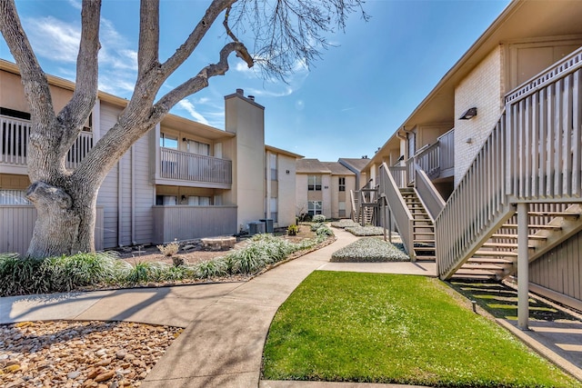 view of property's community featuring a yard and stairs