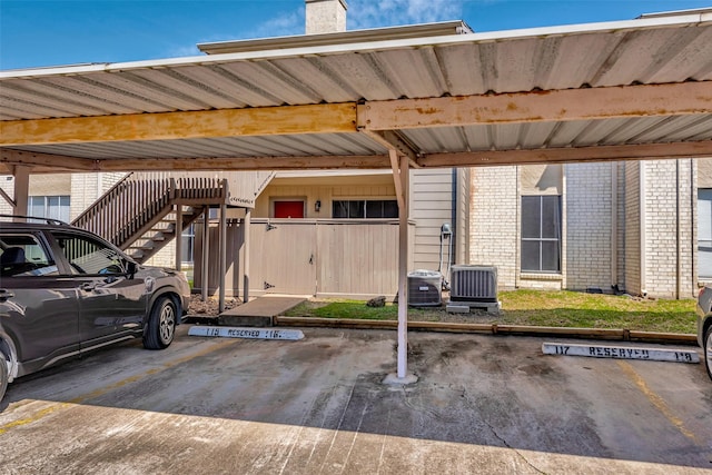 covered parking lot featuring stairway