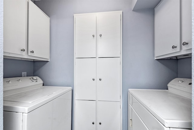 washroom featuring cabinet space and independent washer and dryer