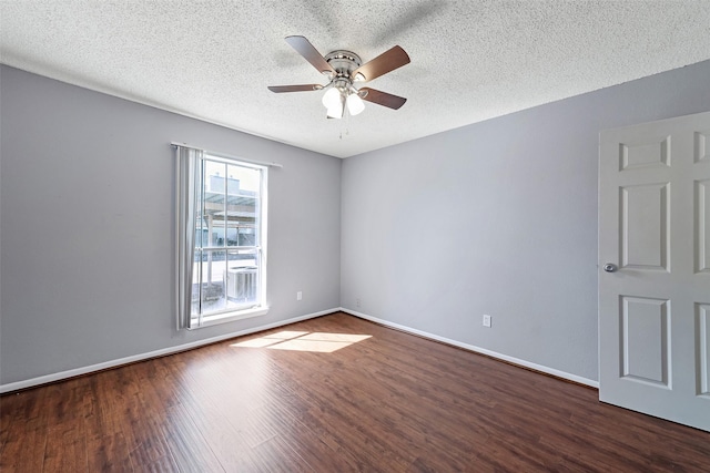 spare room with dark wood-style floors, ceiling fan, a textured ceiling, and baseboards