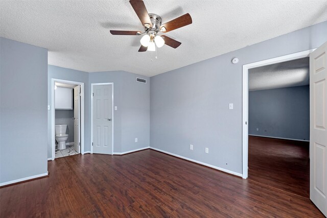 unfurnished bedroom featuring visible vents, a textured ceiling, baseboards, and wood finished floors