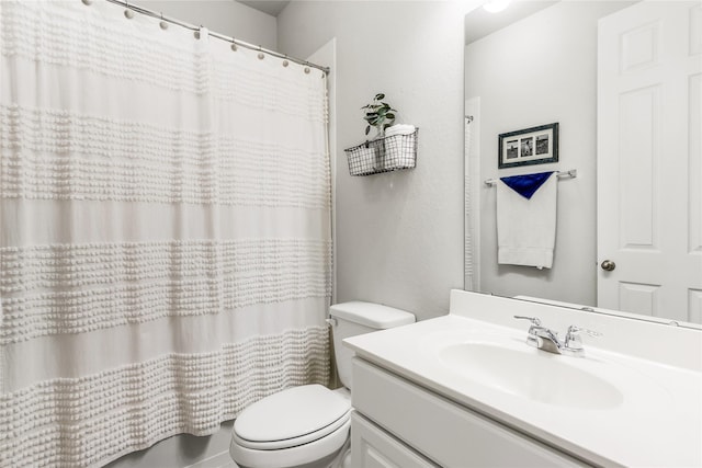 bathroom featuring curtained shower, vanity, and toilet