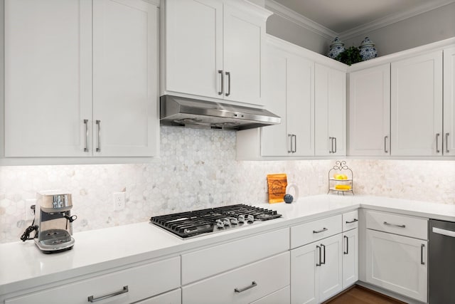 kitchen featuring stainless steel appliances, crown molding, light countertops, under cabinet range hood, and backsplash