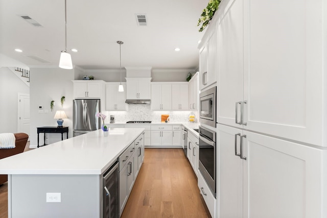 kitchen featuring stainless steel appliances, beverage cooler, visible vents, and decorative backsplash