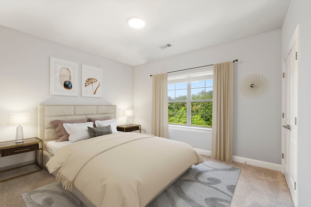 bedroom with baseboards, visible vents, and light colored carpet